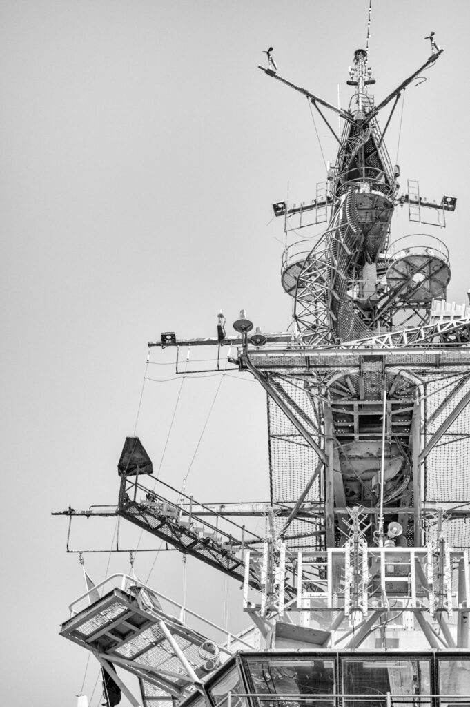 Close-up view of a battleship's intricate structure under a clear sky in San Diego.